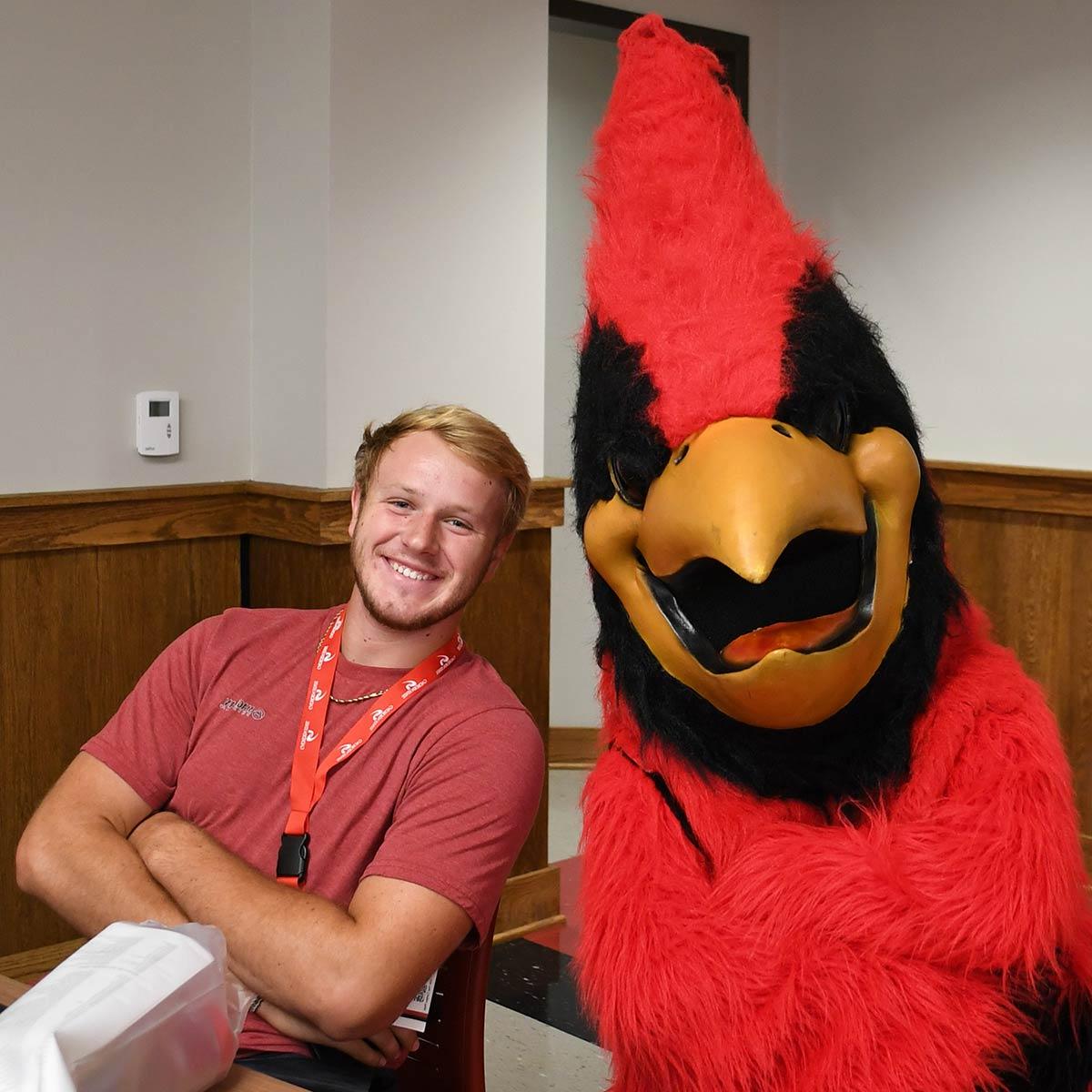 Cardinal mascot Swoop with a student at orientation